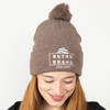 Soft acrylic knit beanie with embroidered design, featuring a 12" knit, 4 top-seams, and a 3" cuff with a pom-pom on top.