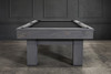Short-wide composition of the Doc & Holliday Dallas Slate Pool Table in Smoke Maple distressed grey finish, photographed during a styled lifestyle shoot. Captures the full Parsons-style base, rustic pine grain, finger-jointed apron detail, and smooth Championship felt surface, staged in a Restoration Hardware–inspired backdrop for a bold Americana presence.