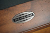 Close-up of the Doc & Holliday steel logo plate proudly stamped “Made in USA” on the Scholar Pool Table | Authentic craftsmanship and solid maple hardwood construction define this mid-century modern slate pool table