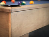 Corner close-up of Paula Parsons pool table by Doc & Holliday in glazed maple with modern Parsons edge on concrete floor