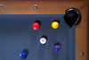 ¾ overhead corner view of The Hank Slate Pool Table by Doc & Holliday Billiards in Americana Chocolate, showing the Championship Titanium felt, leather drop pocket, mother-of-pearl billiard sights, and Doc & Holliday luxury billiard balls.