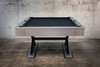 Profile side view of The Metalsmith pool table by Doc & Holliday, showcasing its sleek hardwood body and oversized powder-coated steel X-leg base. Styled with black Championship felt for a modern industrial statement.