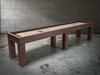 12-foot Paula Parsons Shuffleboard Table by Doc & Holliday in Grey Walnut, angled lifestyle view on concrete floor capturing modern lines, rich maple playfield, and bold Parsons design.