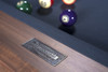 Steel name plate close-up of the Kaci slate pool table by Doc & Holliday Billiards in Grey Walnut. The branding badge is etched into steel, a subtle but powerful nod to authenticity and the American spirit of Doc & Holliday. A refined detail shot that underscores craftsmanship, originality, and confidence in every table.