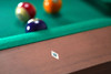 Macro close-up of abalone diamond rail sight on Paula Parsons Pool Table in Grey Walnut finish with billiard balls blurred in background.