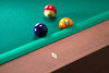 Detail of abalone diamond-shaped billiard site on the Grey Walnut Paula Parsons Pool Table rail with Championship green felt and balls in background.