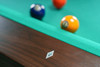 Close-up of mother-of-pearl diamond sights on the walnut rail of the Paula Parsons Slate Pool Table, crafted by Doc & Holliday, highlighting precision detailing for accurate play.