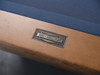 Doc and Holliday steel logo nameplate mounted on glazed maple rail detail of Kaci Slate Pool Table craftsmanship