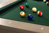 Close-up view across the Championship green felt playing surface of the Doc & Holliday Preakness slate pool table, with billiard balls resting naturally in play. The image emphasizes the depth of the felt, the precision of the slate foundation beneath, and the table’s understated, furniture-driven design.