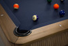 Overhead view of The Slater luxury slate billiard and pool table by Doc & Holliday, showcasing the reeded wood corner detailing, black leather drop pocket, Championship-grade felt, and the Doc & Holliday luxury billiard ball set.