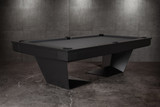 Three-quarter lifestyle view of the Doc & Holliday TRON Slate Pool Table in matte black finish | Ultra-modern industrial steel frame with solid maple hardwood accents and black felt playfield | Photographed in a luxury interior setting, highlighting the sculptural silhouette and dramatic design | USA-made contemporary billiards furniture by Doc & Holliday Billiards