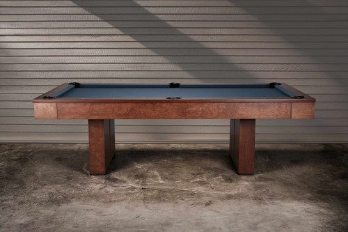 Side view of the Jackies slate billiard table in a contemporary home setting, highlighting its Bourbon Pecan Walnut maple frame and block pedestal base. Leather drop pockets and sleek rails add refinement, while the clean silhouette complements both modern and rustic interiors. A made-in-USA slate pool table designed to be the centerpiece of any game room.