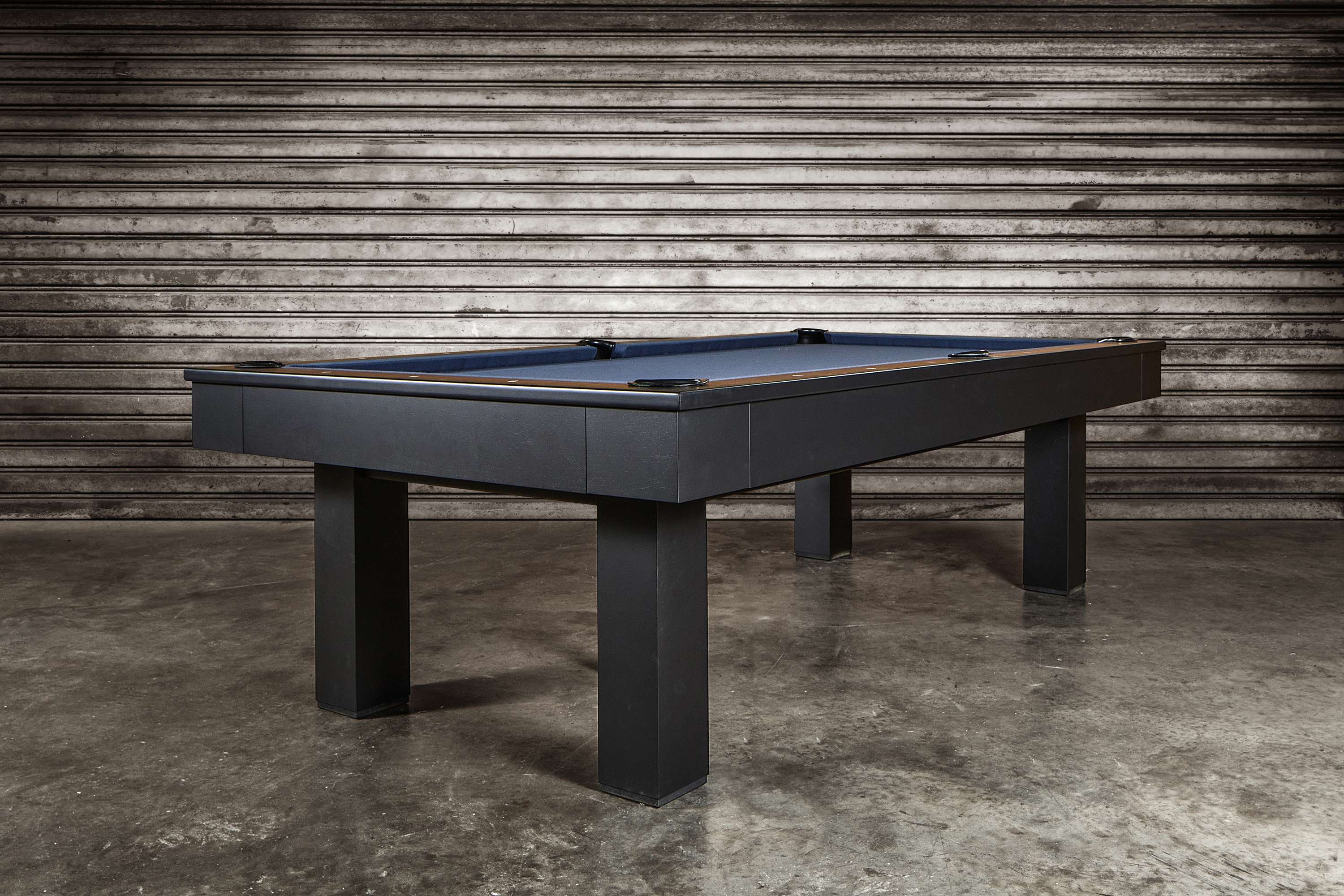 Doc & Holliday Zurich slate pool table shown in Matte Black from a 3/4 angle during the studio product shoot, highlighting the maple accents, leather drop pockets, and professional slate playfield.