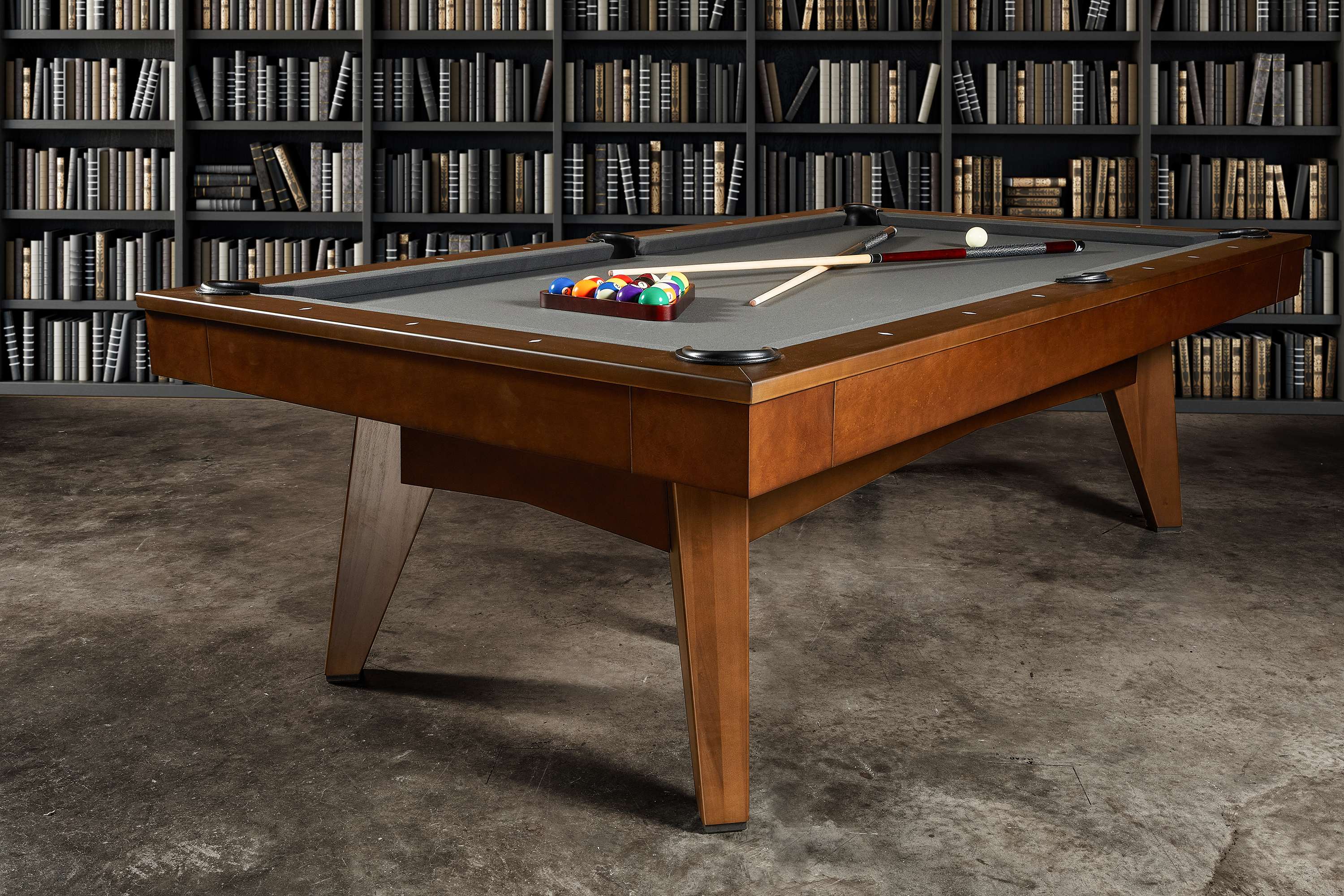 Staged in a richly layered residential study, this image features the Scholar Slate Pool Table in Pecan finish. Surrounded by curated furniture and ambient lighting, the table adds a distinguished presence to the room. The Pecan wood tones create a warm, welcoming atmosphere while the table’s clean lines maintain a minimalist aesthetic. This is a piece that belongs as much in a library as it does in a high-end lounge.
