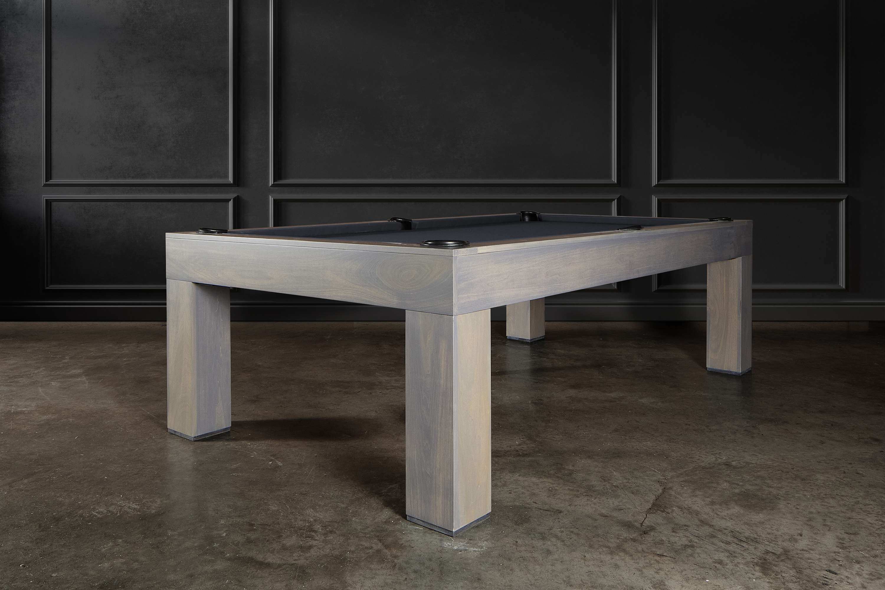 Handcrafted American Parsons-style pool table featured in a designer residential setting. Shown in Grey Wash finish with bold Parsons legs and Championship felt, staged with high-end furnishings and modern lighting for an upscale lifestyle aesthetic.