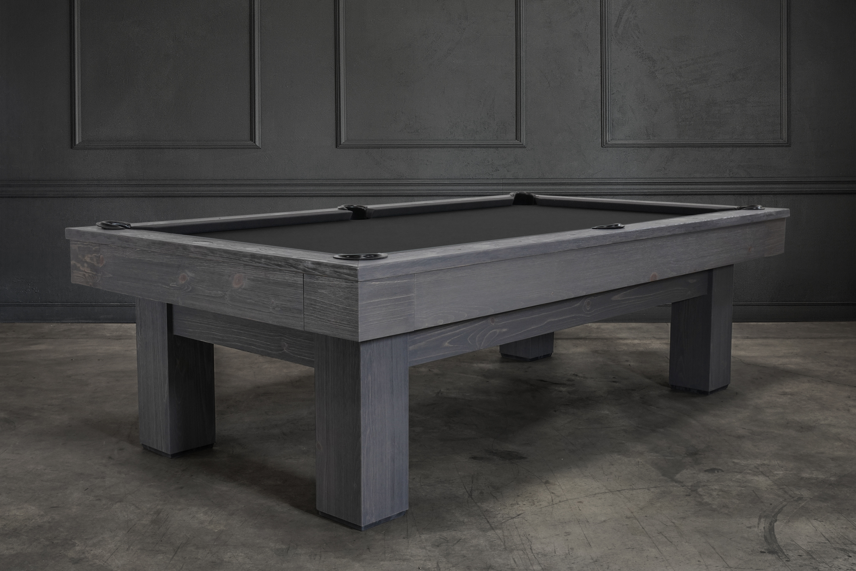 ¾ hero view of the Doc & Holliday Dallas Slate Pool Table in Smoke Maple distressed grey finish, photographed during a styled lifestyle shoot with a Restoration Hardware–inspired backdrop. Highlights the squared Parsons legs, finger-jointed rails and apron detailing, rustic pine texture, and Doc & Holliday luxury billiard balls displayed across the slate playfield.