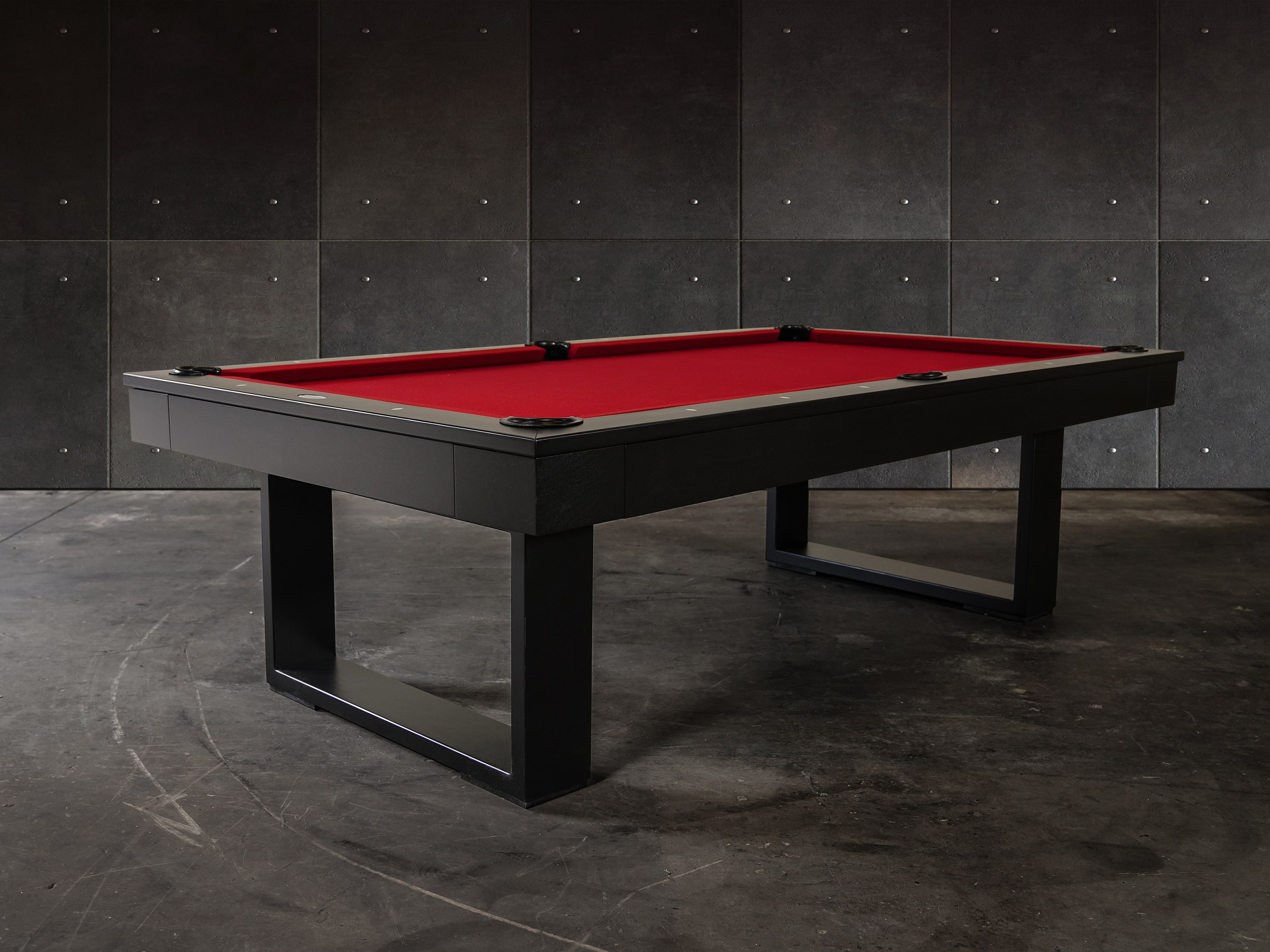 3/4 lifestyle view of the Doc & Holliday Billiards Santorini Slate Pool Table in black finish with red Championship felt styled in a modern high-end residential interior