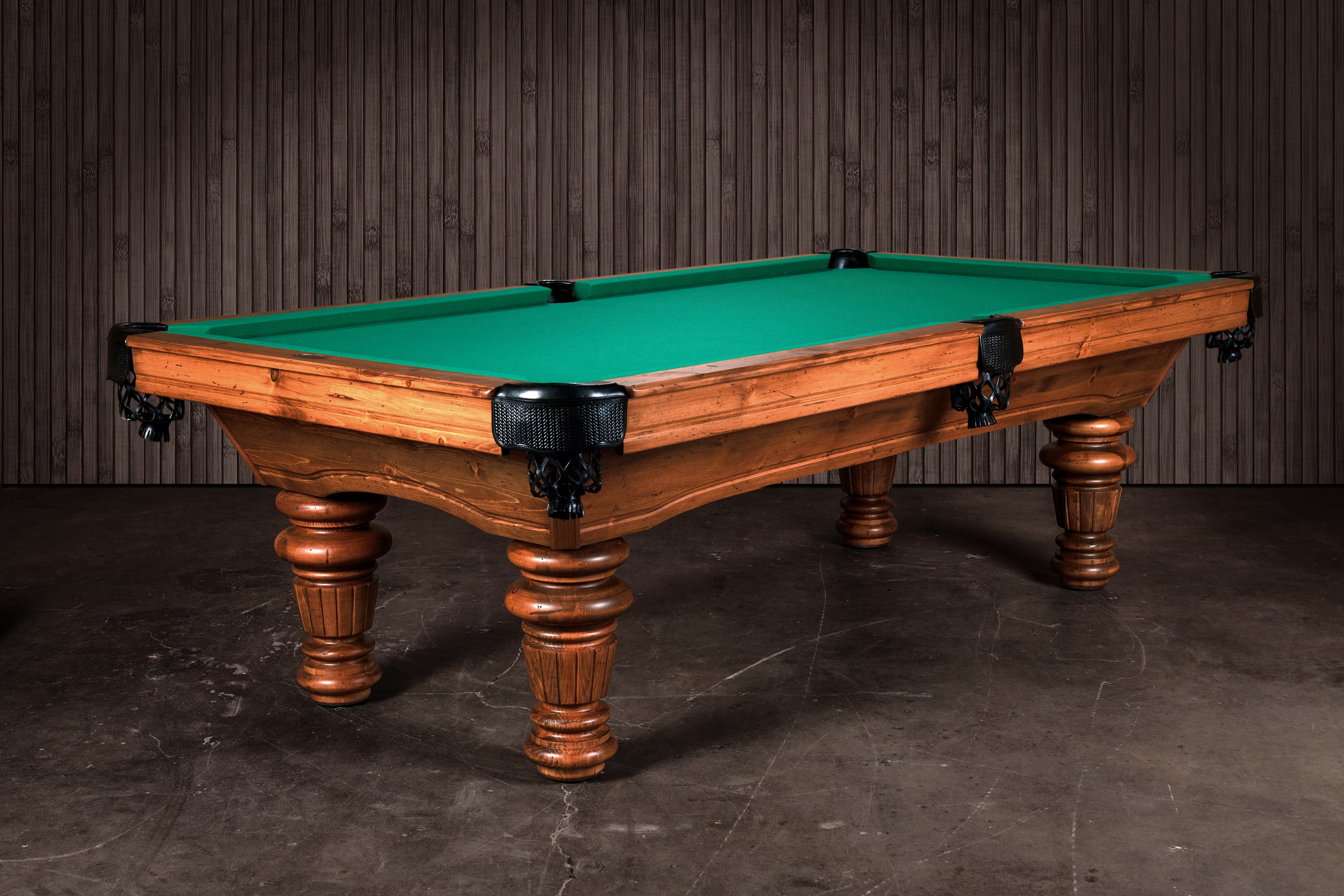 Three-quarter hero view of The Classic Slate Pool Table by Doc & Holliday. Built in the USA from solid Northern Pine with hand-turned fluted legs, this model features a rustic natural finish, green felt, and genuine leather pockets. A timeless Americana design that blends heirloom character with professional-grade performanc