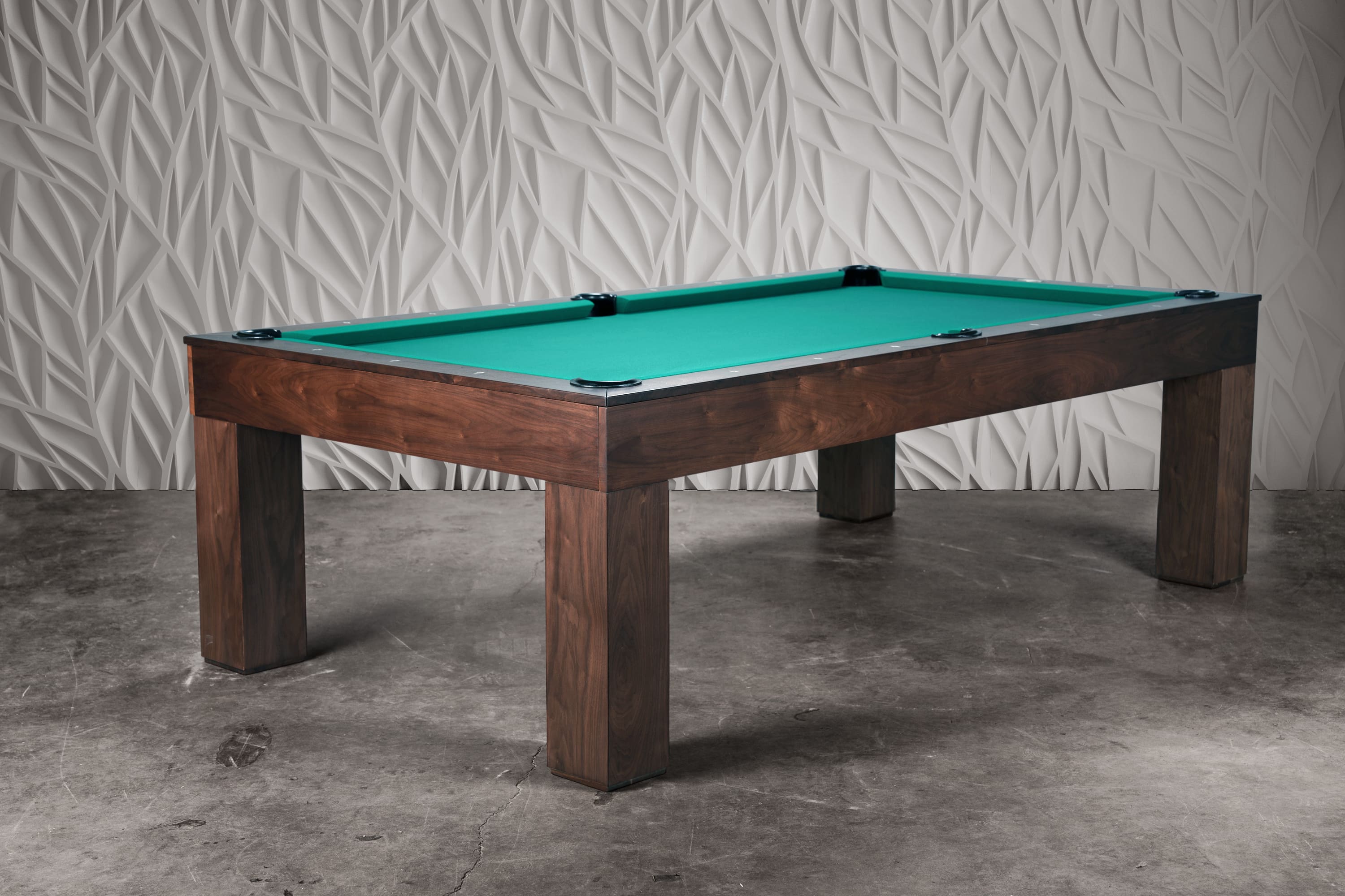 Three-quarter view of the Paula Parsons Slate Pool Table in natural walnut, photographed in a professional studio with Restoration Hardware–style backdrop, showcasing its Parsons silhouette and architectural presence.