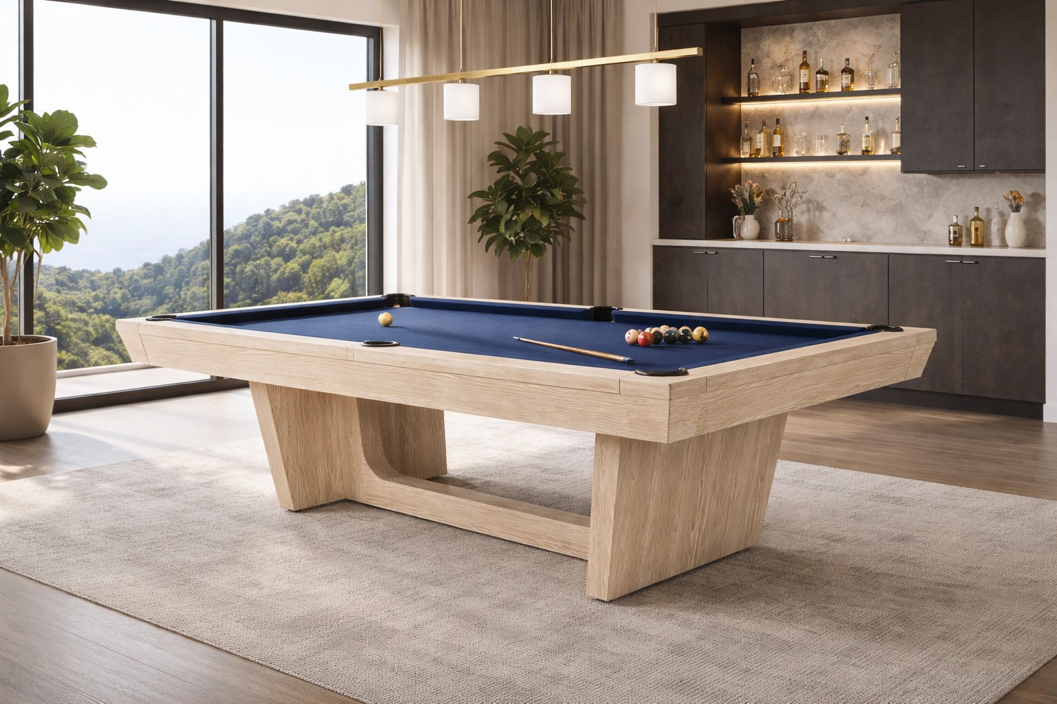 Doc & Holliday Kaci 8-ft slate pool table in Natural Ash finish with navy blue felt, photographed in a modern luxury game room with floor-to-ceiling windows, light oak wood grain detail, contemporary pedestal base, and interior design-inspired setting.