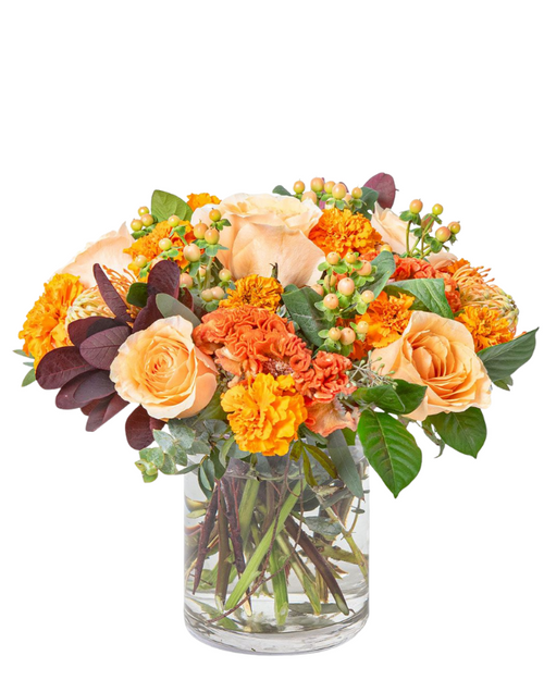 Marigold Luxe cylinder bouquet with peach roses, marigolds, coxcomb, protea, hypericum, smokebush, and eucalyptus in Albuquerque NM.