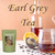 A glass jar of brewed Earl Grey tea sits next to a tea infuser, a sliced lemon, and loose black tea leaves on a table.