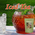 A large glass pitcher filled with iced tea, ice cubes, and a sprig of fresh mint stands next to an empty glass of ice.