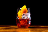 York Gin Chocolate & Orange  negroni in branded tumbler with orange garnish on dark background.