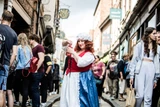 Mad Alice holding a bottle on Shambles, York