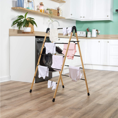 Folding bamboo clothes airer with five black rails, shown open.