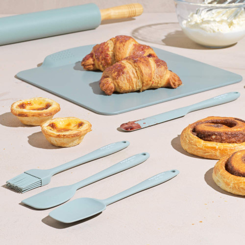Set of pastel blue silicone baking utensils and board shown with pastries.