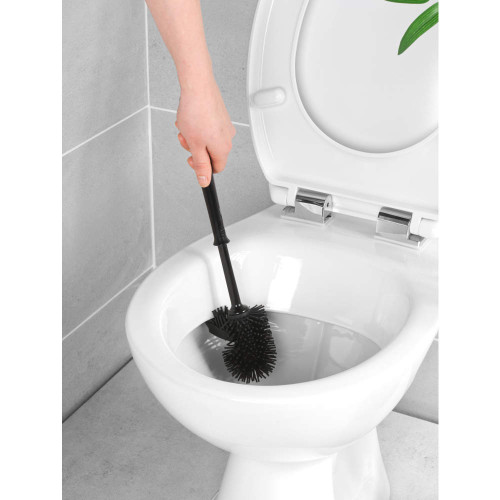 Black silicone toilet brush cleaning inside white toilet bowl