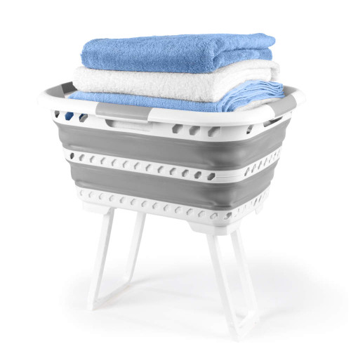 Collapsible grey plastic laundry basket with legs, holding folded blue and white towels