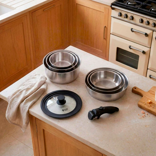 Silver kitchen timer on cream countertop beside oven and chopping board