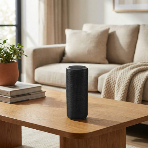 Black portable wireless speaker on wooden table in modern living room