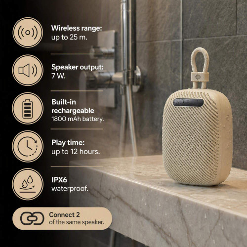 Cream waterproof portable speaker with carry loop shown on bathroom shelf