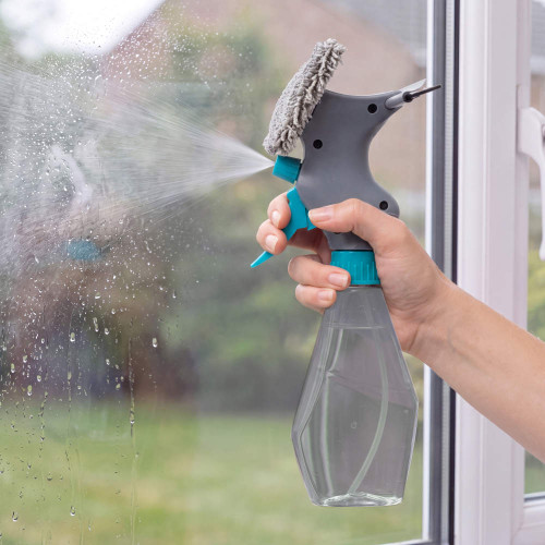 Handheld window spray cleaner with microfibre pad in use on glass