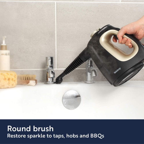 Handheld steam cleaner cleaning oven interior with steam.