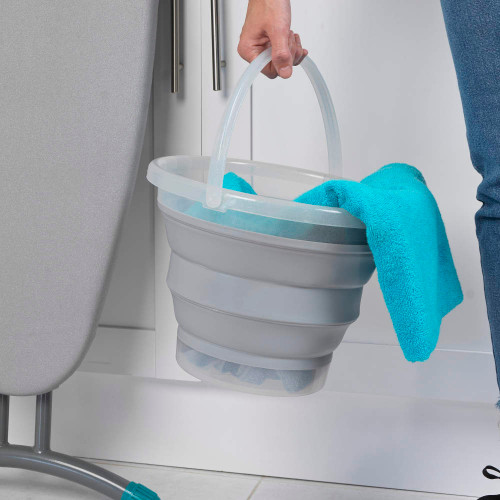 Grey collapsible bucket with turquoise cleaning cloth, held by a person