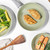 Green ceramic frying pan with cooked chicken breasts, shown from above