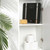 Black digital bathroom scale with silver accents on shelf beside bath sponge