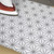 Grey geometric patterned ironing board cover with iron in use
