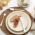 Set of four silver cutlery pieces on cream stoneware plates, for product listing