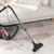 Vacuum cleaner hose cleaning grey carpet stairs