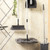 Cleaning set with grey broom, mop, dustpan, and bucket against wall.