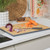 Bamboo chopping board with cut carrot and red onion on kitchen counter