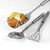 Set of three stainless steel kitchen tools, one lifting fishcake with lemon garnish.