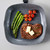 Grill pan with cooked steak, asparagus, and cherry tomatoes, viewed from above