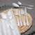 Silver stainless steel cutlery set with knives, forks, spoons on woven placemat