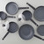 Non-stick black cookware set with saucepans, frying pans, and glass lids